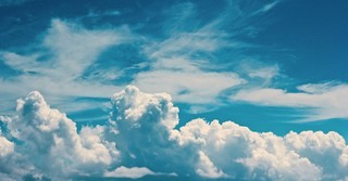 Fluffy clouds against a bright blue sky