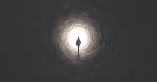 Man walking down dark tunnel toward light, the lord is my shepherd even in the valley of the shadow of death