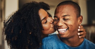 Wife happily kissing her husband on the cheek