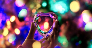 Cut crystal heart with Christmas lights behind it, shining through