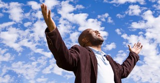 Joyful man raising arms in worship