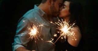 Couple kissing while holding sparklers