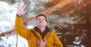 Man praying with hand over heart