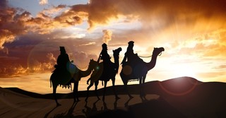 Three wise men riding camels in the desert