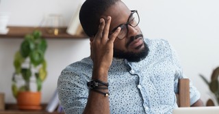 Man sitting at his desk looking uncertain