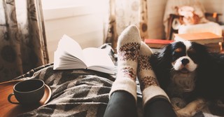 Woman resting with a dog and a book
