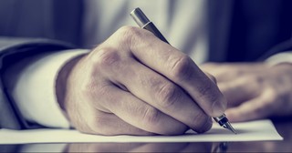 Close up of a man's hand writing