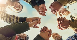 Ground shot of a group of people with hands held in prayer