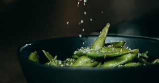 Salt seasoning a bowl of edamame