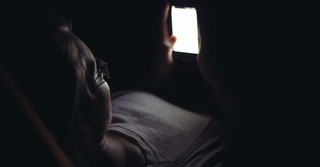 Woman looking at her phone in the dark