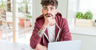 Young man looking up thoughtfully