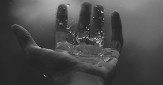 Rain dropping on a person's hand