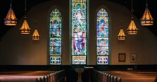 Church sanctuary with ornate stained glass windows