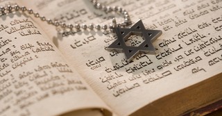 Star of David necklace on top of the Hebrew Bible