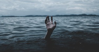 hand reaching out from lake