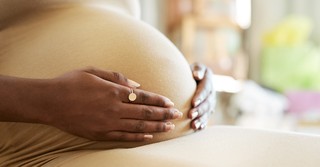 A pregnant woman with her hands on her belly