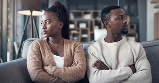 A couple with crossed arms, looking away from each other. Angry