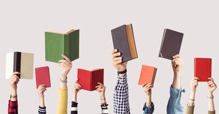 Hands of people holding up books