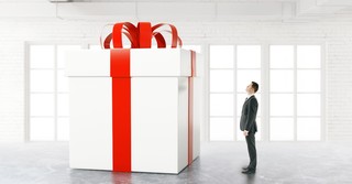 A man staring up at an enormous, wrapped package