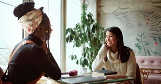 Two young women having a conversation at a cafe