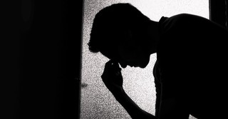 silhouette of man holding his head, sad