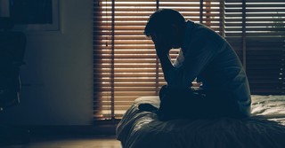 stressed person sitting on bed