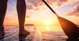 A paddle-boarder on the lake at sunrise.