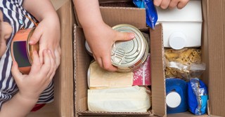 kids packing meals in a cardboard box