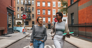 Two women walking down a street talking