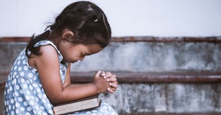 a little girl praying