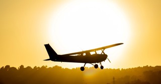 Silhouette of a small airplane at sunset