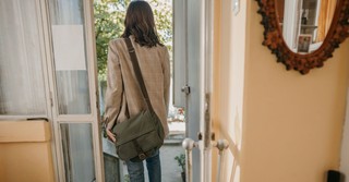 A woman leaving her house with a bag