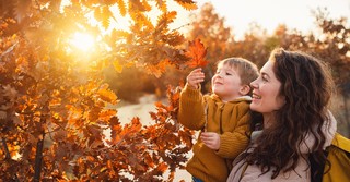 Woman with son and fall leaves, gratitude tree
