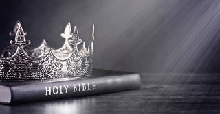 A silver crown on top of a Bible