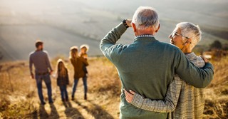 Proud grandparents senior couple watching family hiking on hill