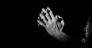 Black and white photo of hands folded in prayer
