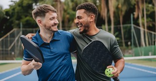 Two men, friends, laughing together after playing pickleball