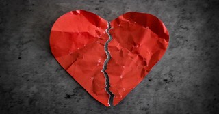 Crumpled paper heart torn in half