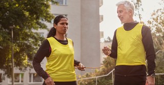 A blind runner talking with the man guiding her