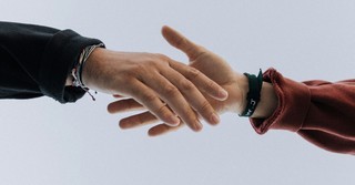 Two people reaching out to shake hands