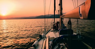 A sailboat on the water at sunset