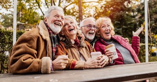 Happy seniors friends in fall outside at park laughing
