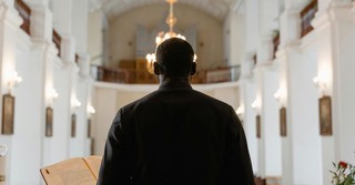 Back view of a pastor standing in front of a congregation