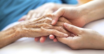 an older and younger person cupping each others hands, Study finds that atheists like those of other faiths more than Christians do