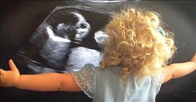 Big Sister Hugs Ultrasound Of New Baby 