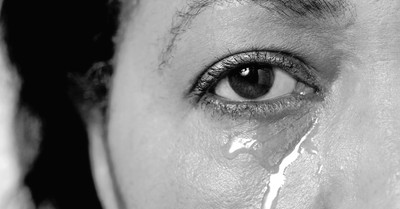 A woman crying, why would a loving God allow suffering
