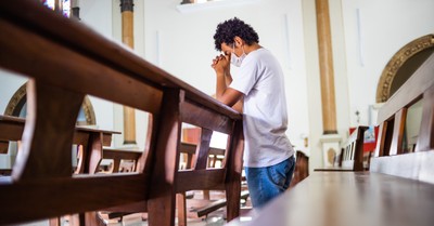 A man praying in a church, NYT article calls churches a major hub for coronavirus spread