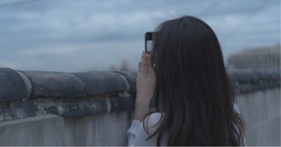 A woman taking a photo, Chinese officials offer money to citizens who get photos of underground churches