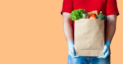 A Man holding a bag of food, 76 percent of people want to focus on those in need this Christmas