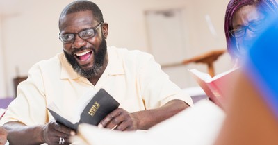 a man holding a Bible, new survey reveals weekly churchgoers have better mental health